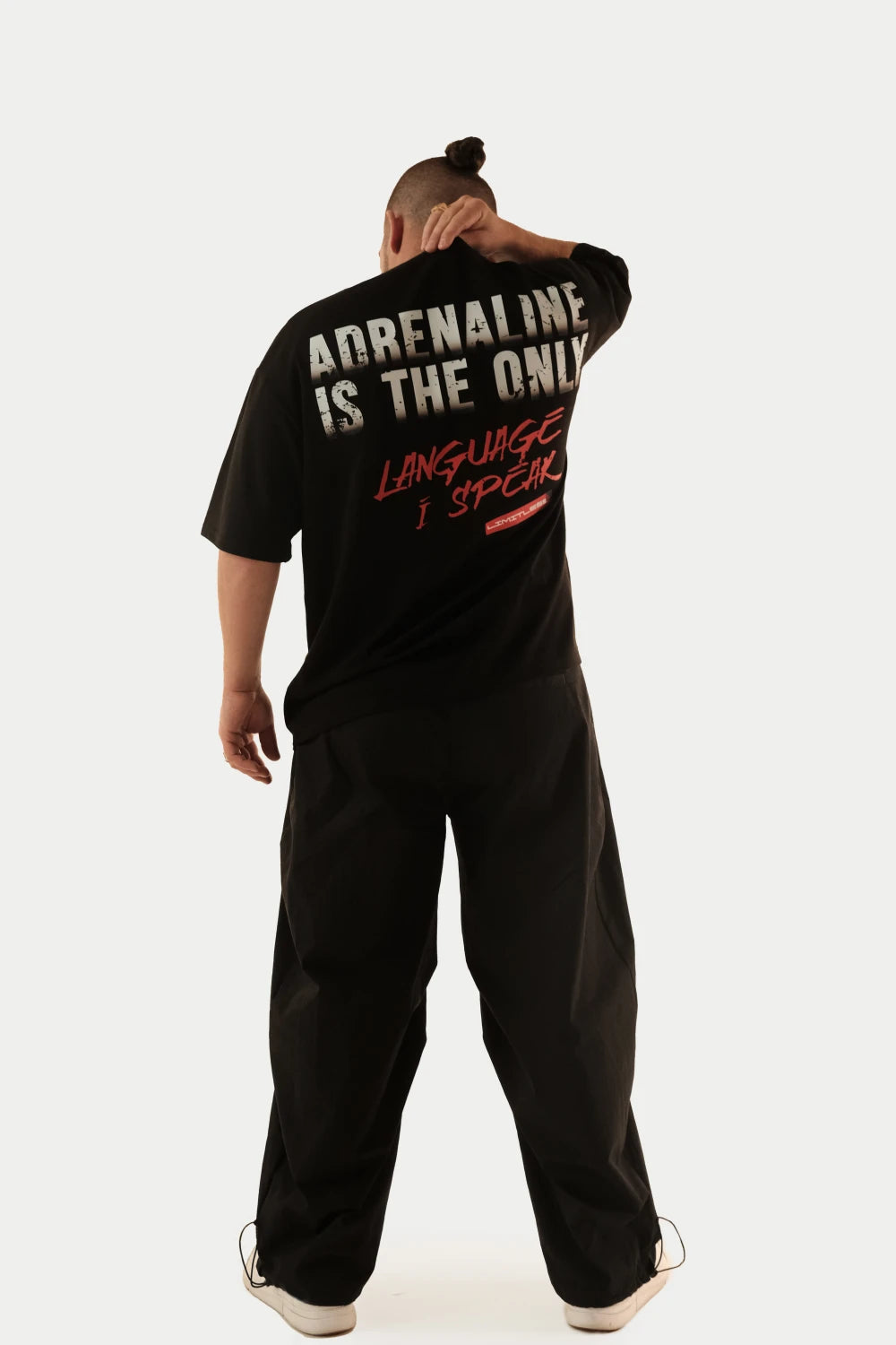 Male model wearing Racer Nation Adrenaline Only black oversized tee showing large white and red back graphic