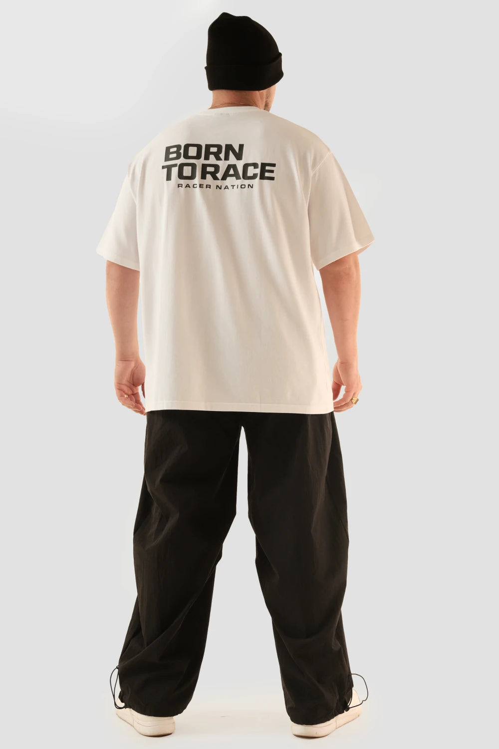 Male model wearing Racer Nation Born To Race white oversized tee showing the large black back print