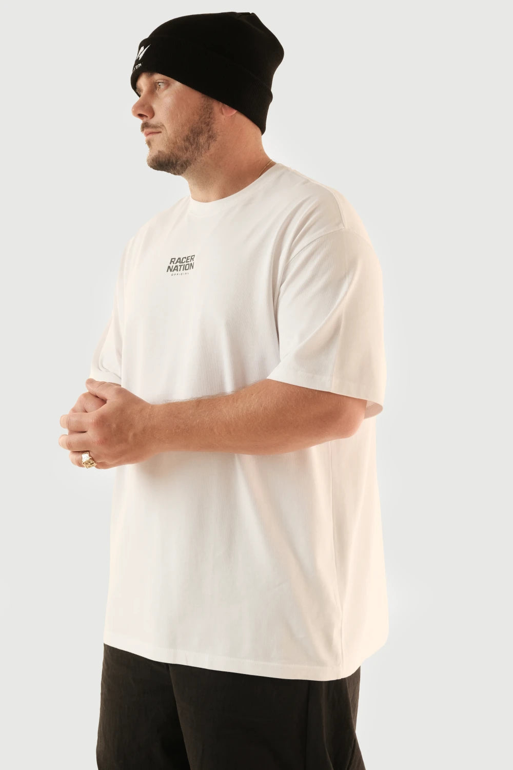 Male model wearing Racer Nation Born To Race white oversized tee showing small front chest logo and relaxed fit
