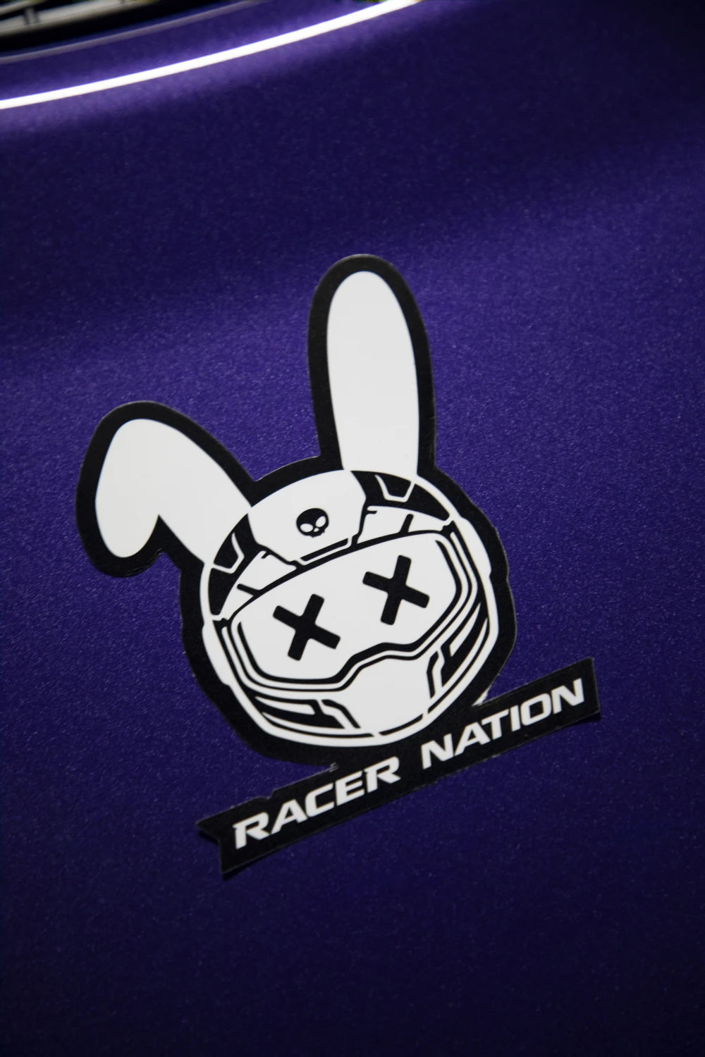 Black and white Racer Nation bunny helmet sticker displayed on the bonnet of a purple car.