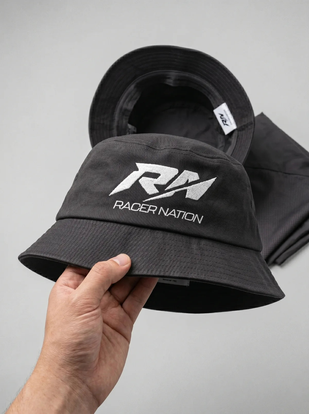 Classic black Racer Nation bucket hat featuring the embroidered white RN logo on the front.