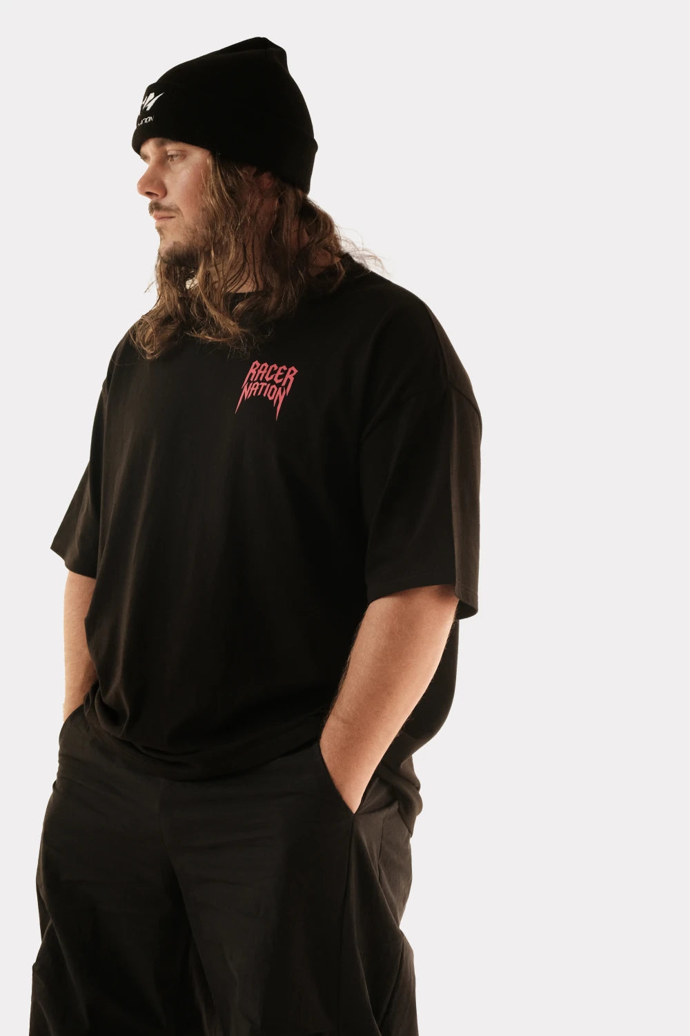 Male model wearing Racer Nation Ghost Rider black oversized tee showing red Racer Nation front chest graphic and relaxed fit