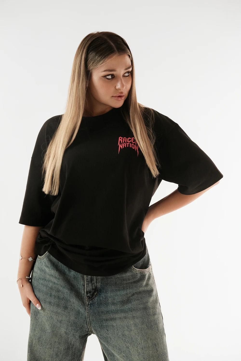 Female model wearing Racer Nation Ghost Rider black oversized tee showing red front chest graphic and relaxed oversized fit