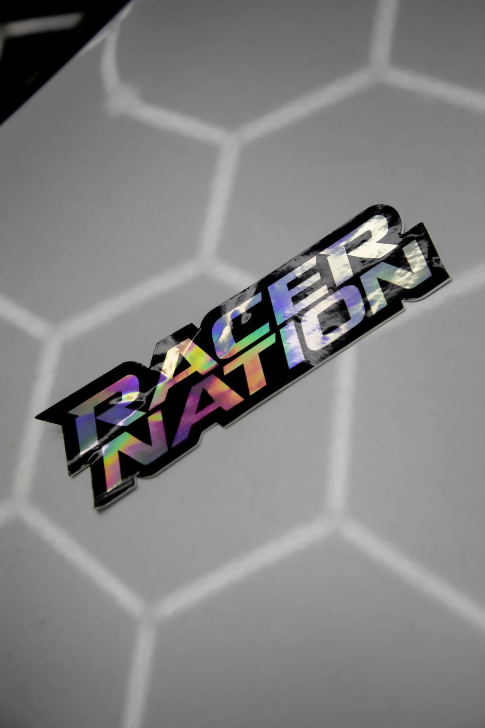 Close-up of the holographic Racer Nation logo sticker showing its reflective rainbow finish.