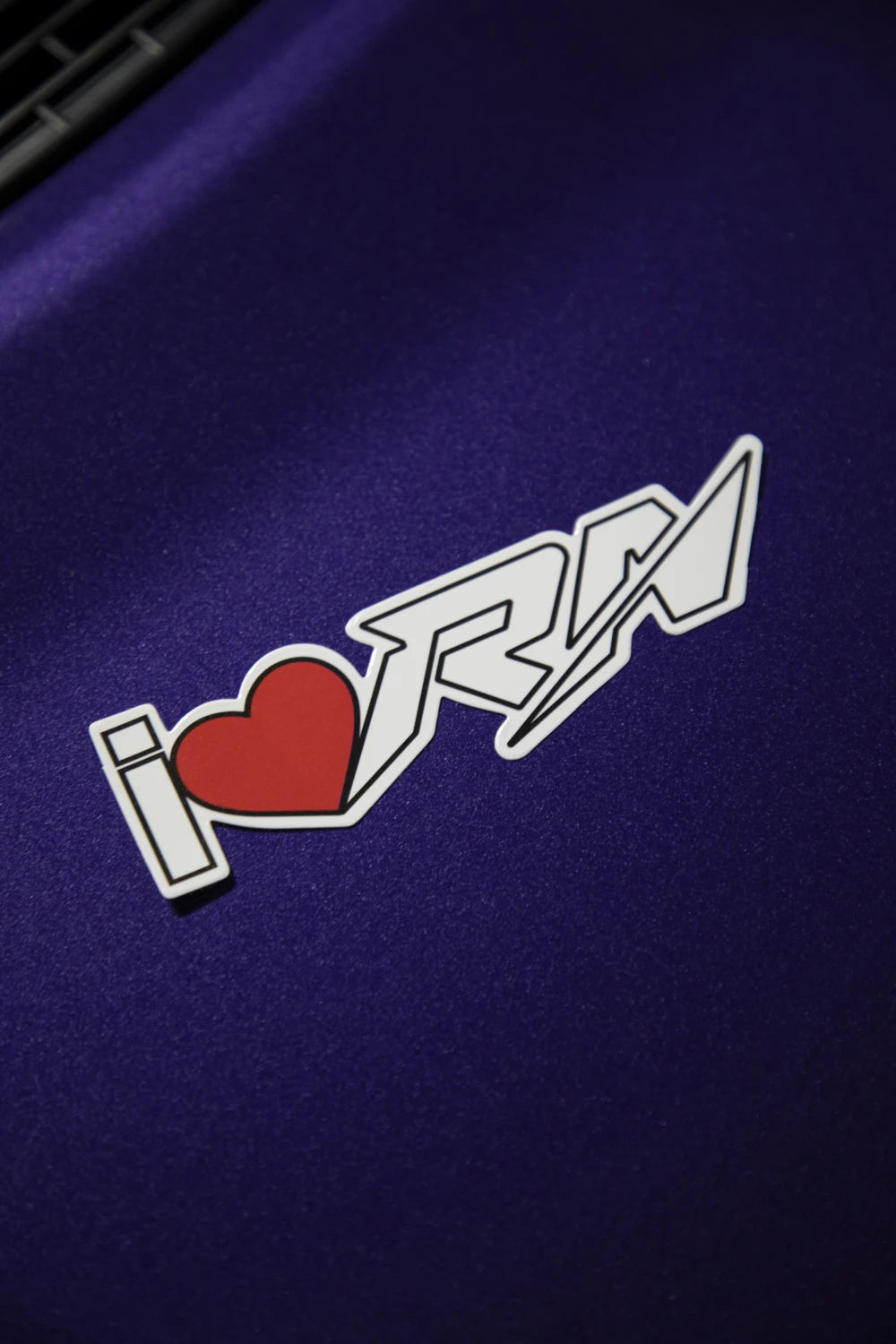 I Love RN sticker featuring a red heart and white Racer Nation logo displayed on a purple car.