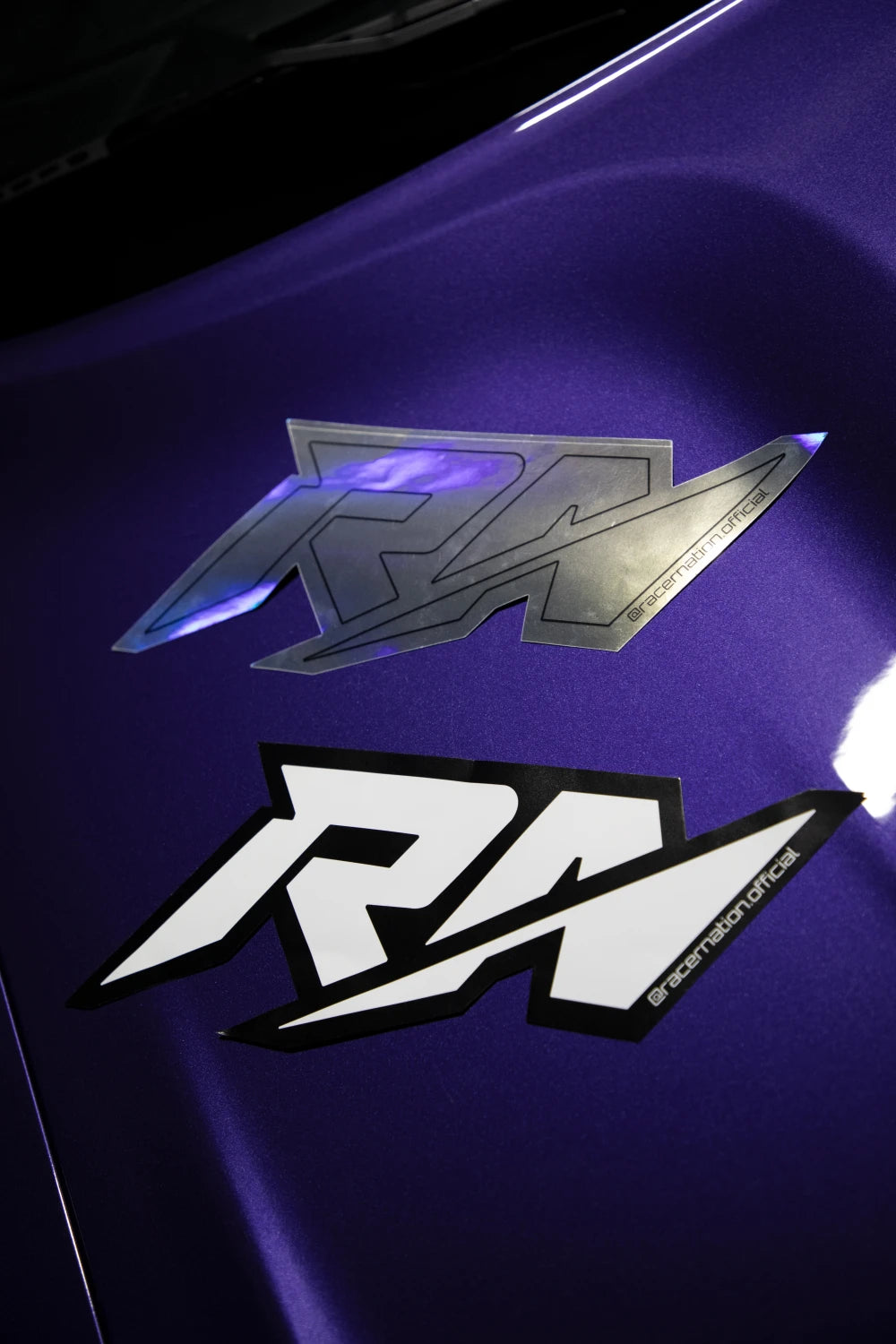 Large Racer Nation RN logo stickers in holographic and black and white finishes displayed on a purple car.