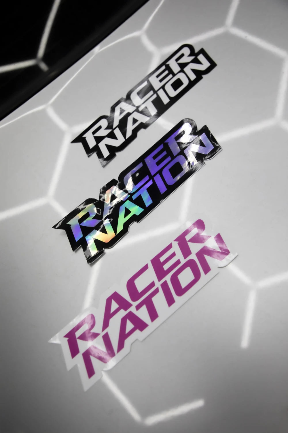 Racer Nation logo stickers shown in black and white, holographic and pink colour options.