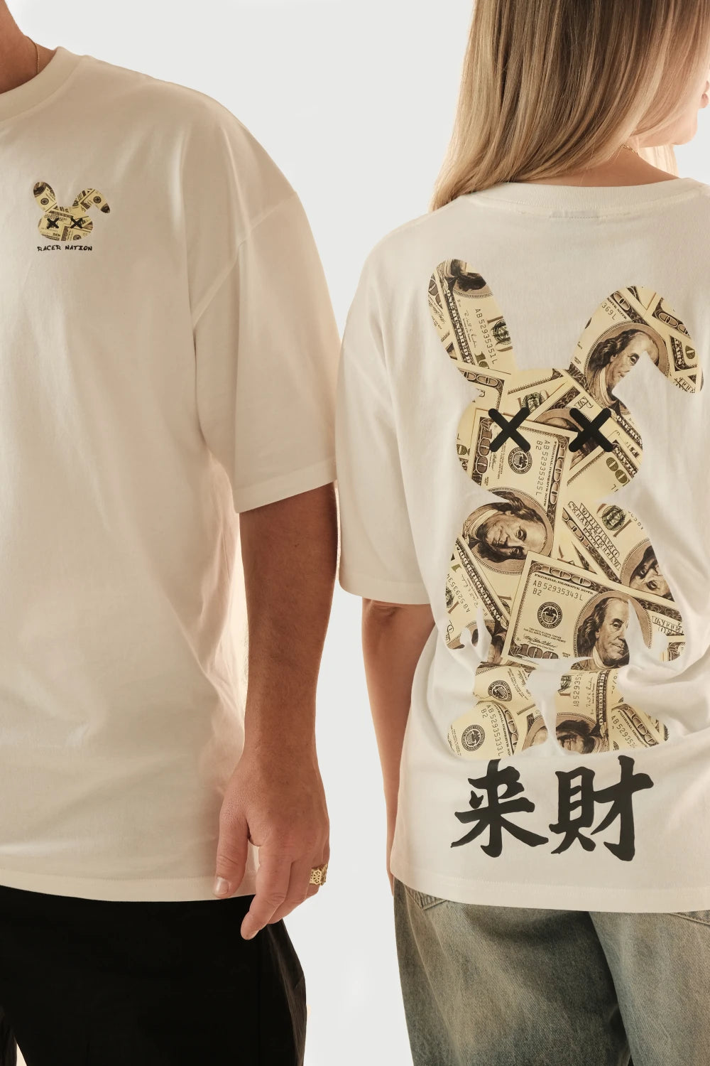 Male and female models wearing Racer Nation Money Bunny white oversized tee showing small front chest graphic and large money bunny back print