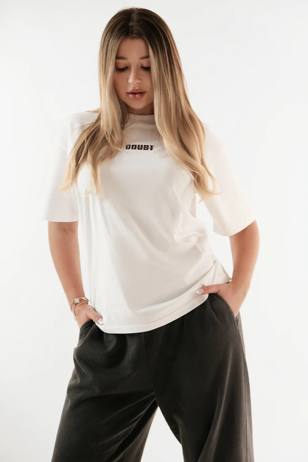 Female model wearing Racer Nation No Doubt white oversized tee showing small front chest logo and relaxed oversized fit