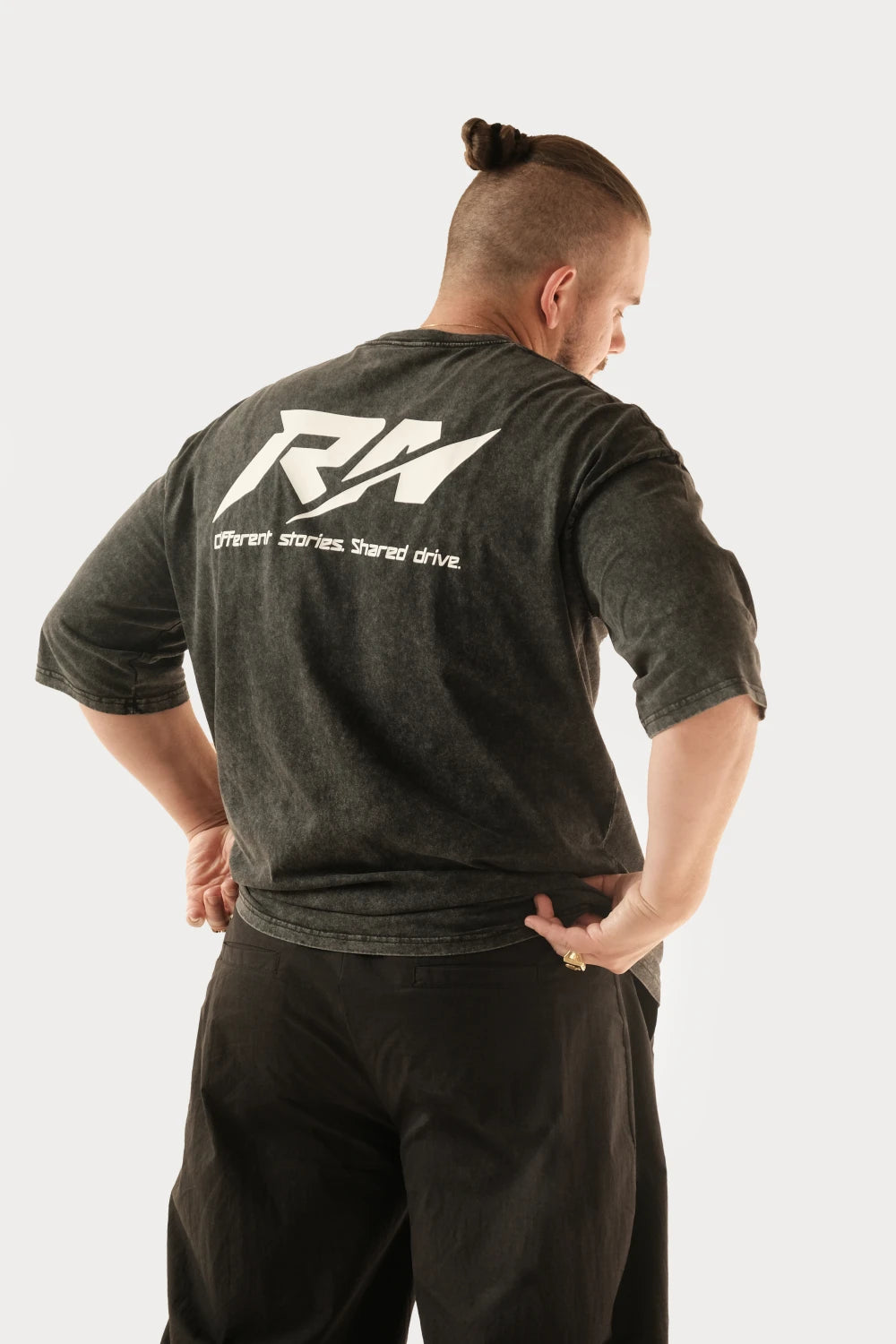 Male model wearing Racer Nation RN OG black acid washed oversized tee showing large white back logo