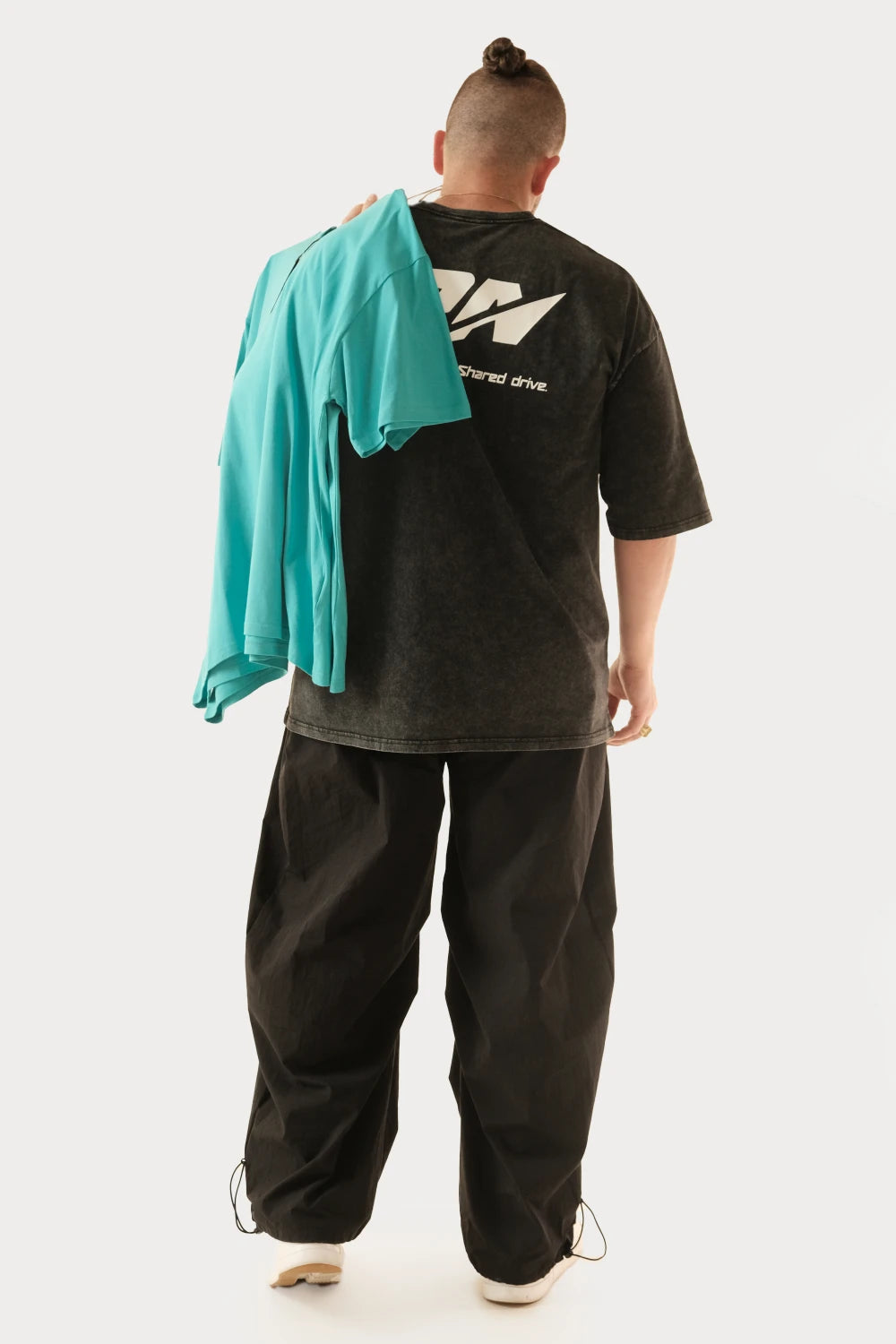 Male model wearing Racer Nation RN OG black acid washed oversized tee showing large white back logo