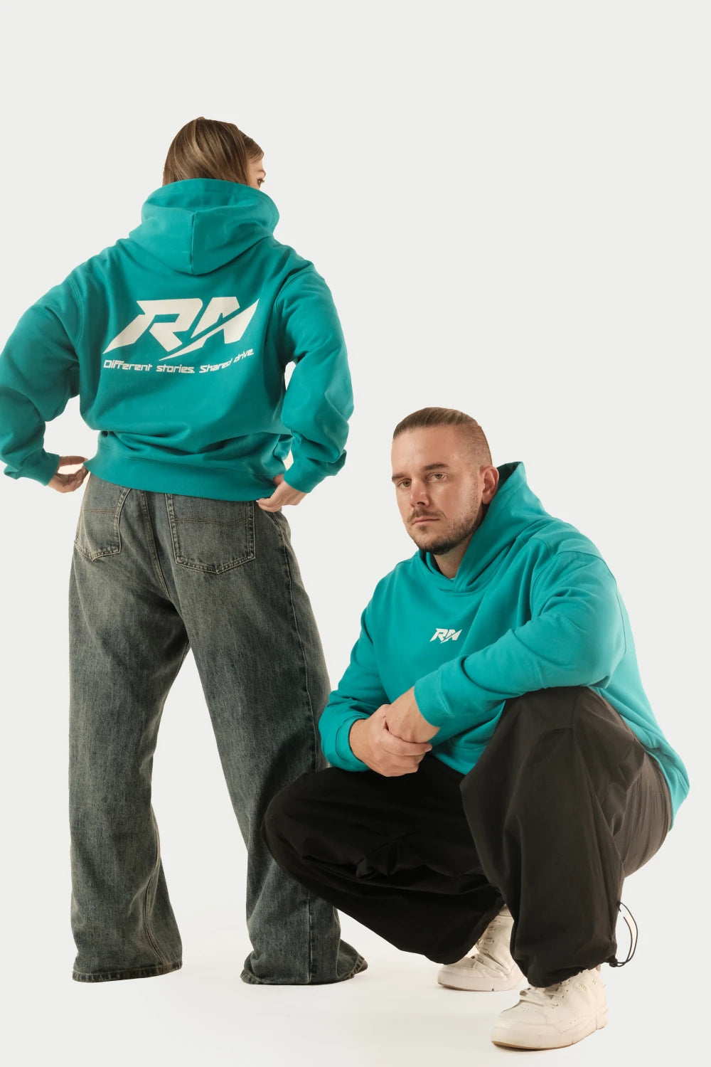 Two models wearing Racer Nation RN OG oversized hoodie in Tiffany Blue, showing front chest logo and large back logo