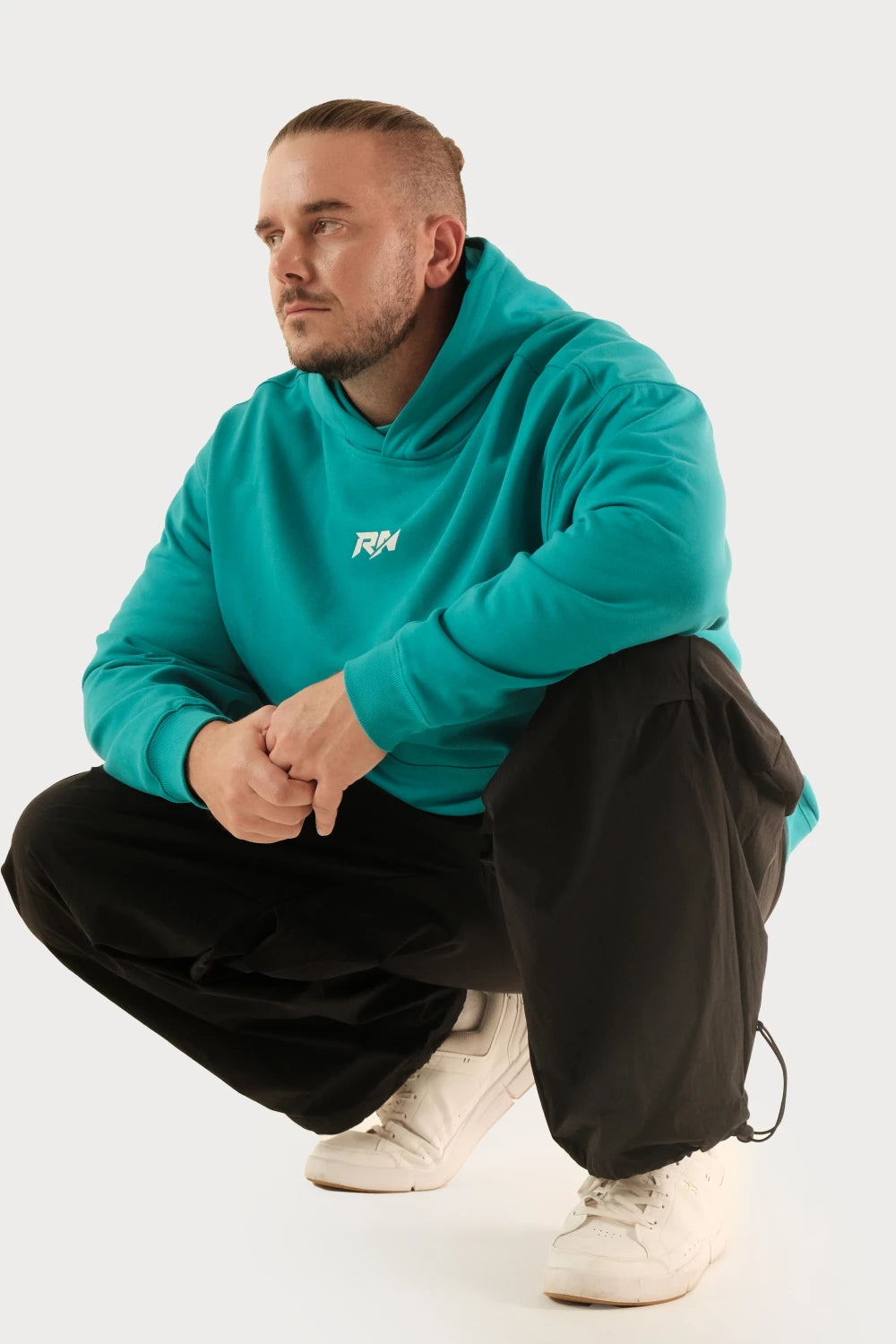 Male model wearing Racer Nation RN OG oversized hoodie in Tiffany Blue showing front logo and relaxed oversized fit