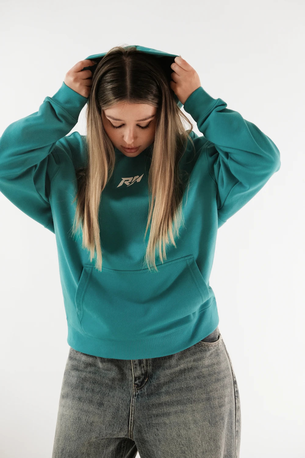Female model wearing Racer Nation RN OG oversized hoodie in Tiffany Blue showing front logo, hood and relaxed fit
