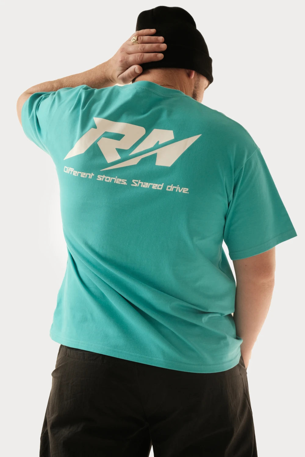 Male model wearing Racer Nation RN OG Tiffany Blue oversized tee showing large white RN back logo