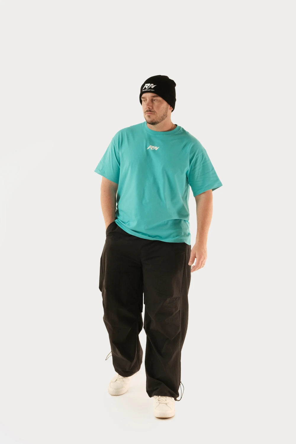 Male model wearing Racer Nation RN OG Tiffany Blue oversized tee showing white front chest logo and relaxed fit