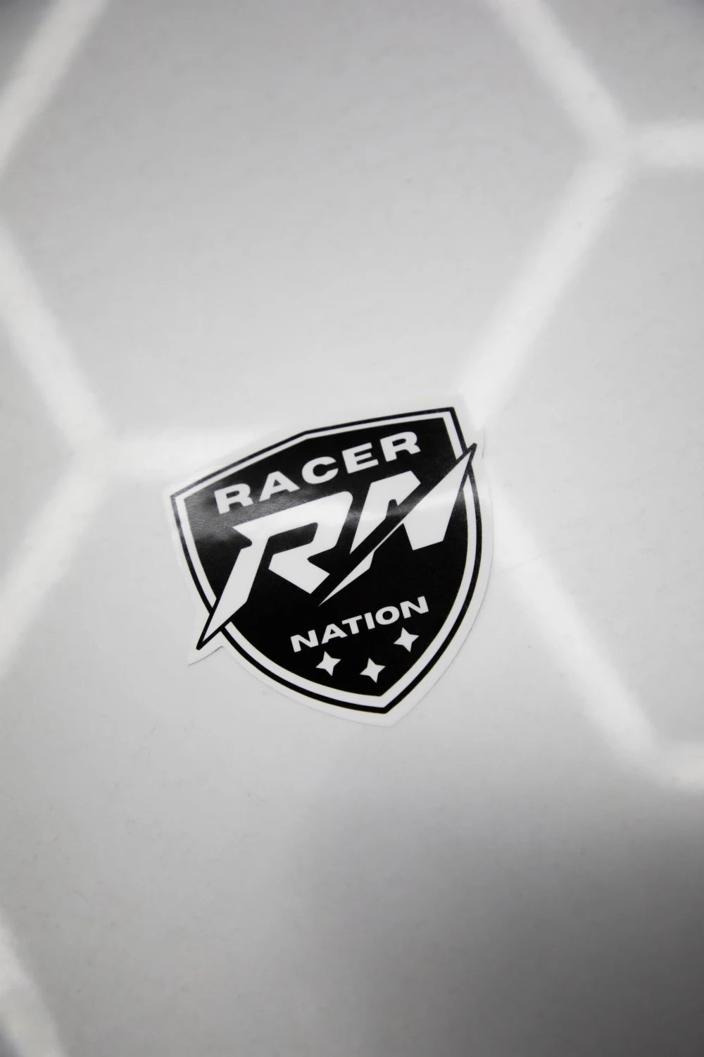 Black and white Racer Nation shield logo sticker displayed on a white surface.
